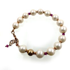 Armband zoetwater parels met kleine rode spinellen.